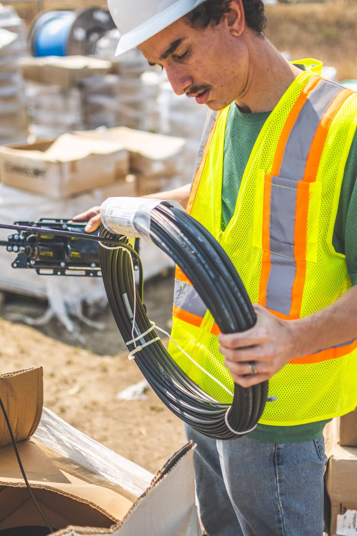 Engineer inspecting fiber optic cable during an installation project